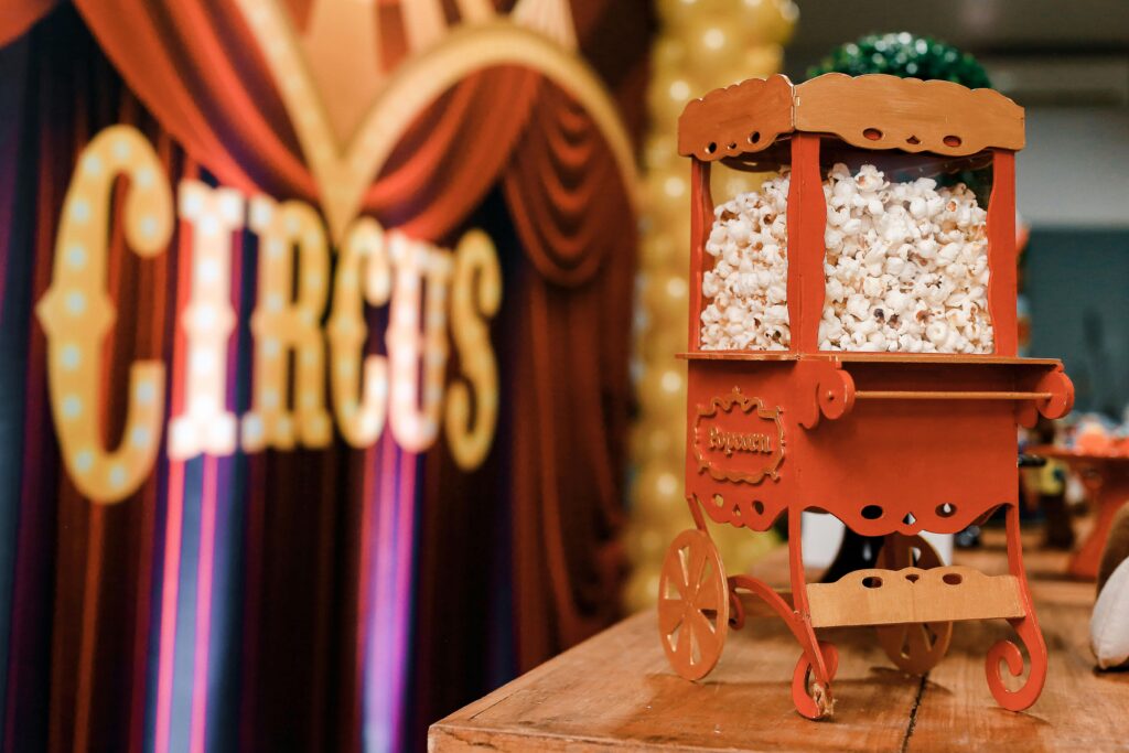 Close-up of a vintage popcorn cart at a circus-themed event, evoking nostalgia and excitement.